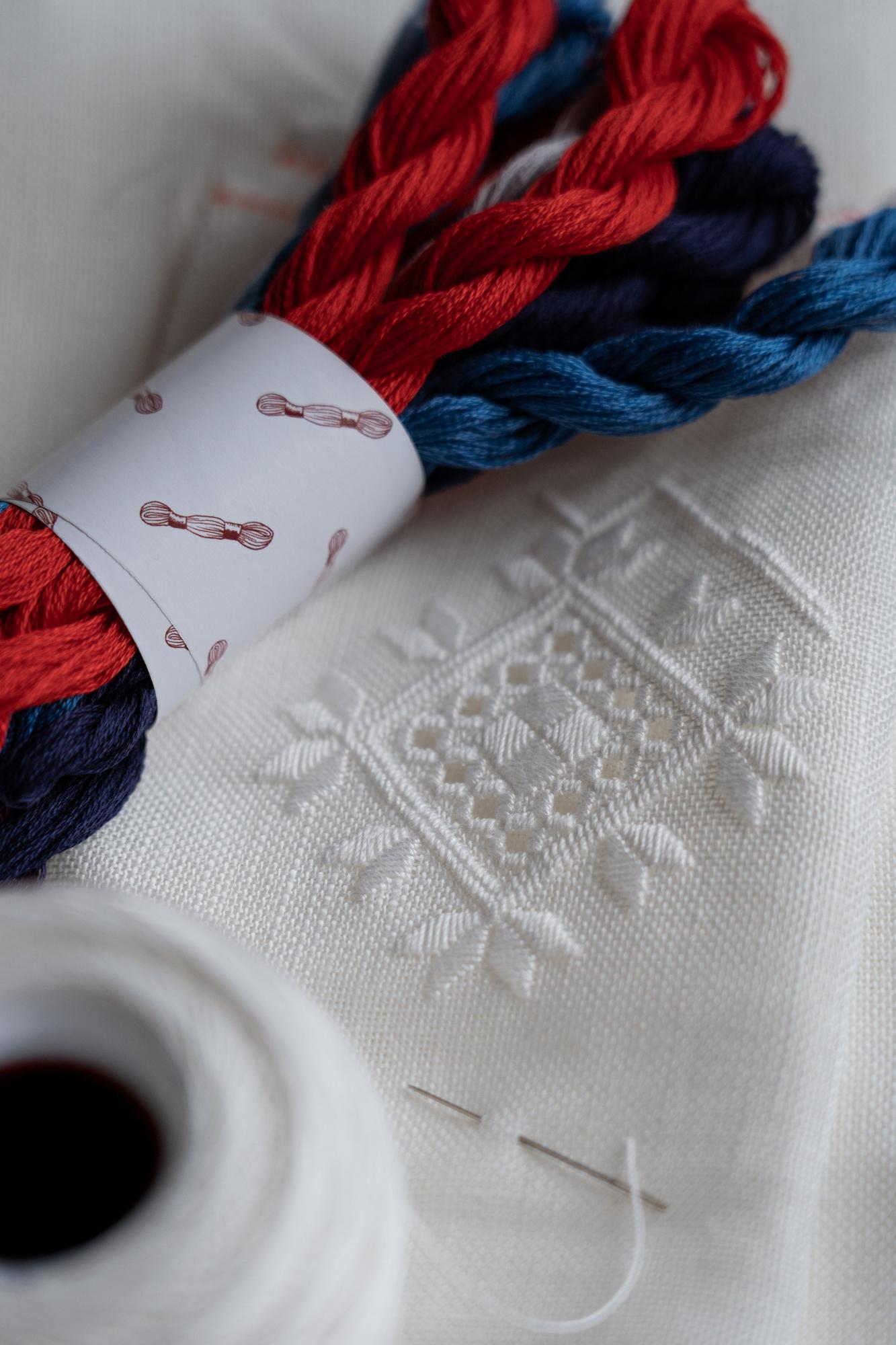 Close view of satin-stitch initials on cotton napkin